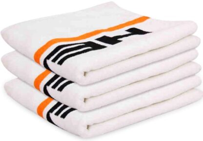 White towel with orange details and HEAD in black writing on each end. 3 towels folded and stacked.