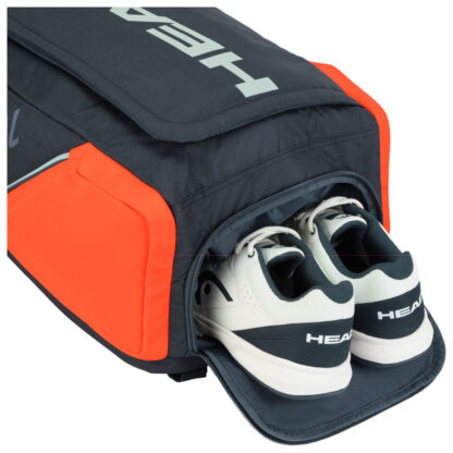 Top view of HEAD tennis bag. Black bag with gey HEAD writing down the middle and orange sides. Top with room for shoes.