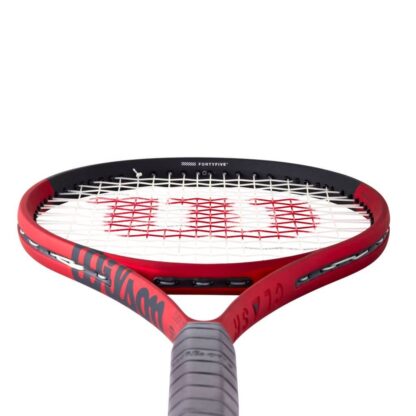 View from grip of red matte tennis racquet with black top, white strings with red logo and black grip. Wilson Clash 100 v2.0.
