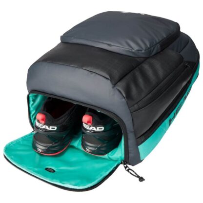 View from bottom into the bottom room for shoes of black backpack from HEAD with white HEAD logo on the front. Turqoise inner lining. Side room for water bottle, two seperate rooms and a room at the bottom for shoes. One side is turqoise and one side is orange. Matches the HEAD Gravity 2019 model.