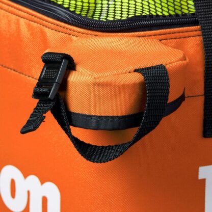 Closeup of square bag for tennis balls from Wilson in orange. Black mesh on the top with white Wilson logo. Wilson in white writing on the sides of the bag.