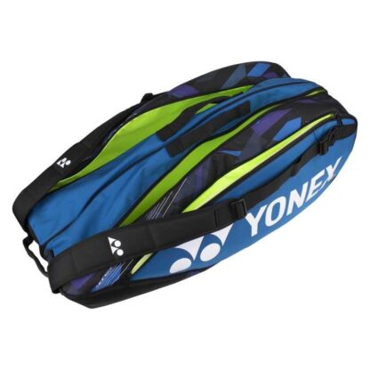 Blue racquet bag from Yonex. Racquet bag for 6 racquets. Yonex in white writing along white Yonex logo. Details in black and different shades of blue. 3 opened compartments.