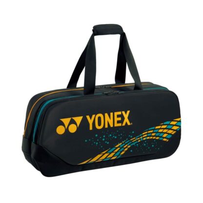Black rectangular racquet bag from Yonex. Yellow/gold Yonex logo on the front. Yellow/gold and turquoise details.