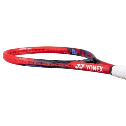 Lying view of red, black and blue tennis racquet from Yonex. White grip. Yonex in silver writing on the side with silver Yonex logo. Yonex Vcore 100L 2023 model.