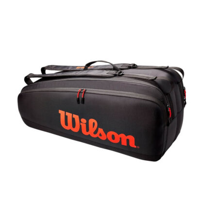 Black tennis bag with red/orange details. Wilson in red/orange writing on the side.