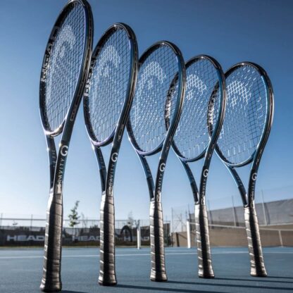 Line up of black and blue pearlescent tennis racquet from HEAD. Black strings with white HEAD logo and black grip. HEAD Gravity MP Auxetic 2025.