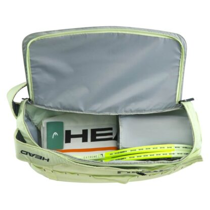 Lime/ light green duffle bag from HEAD with HEAD branding detail. Shown open where the compartment is filled with racquets, towels and other accessories.