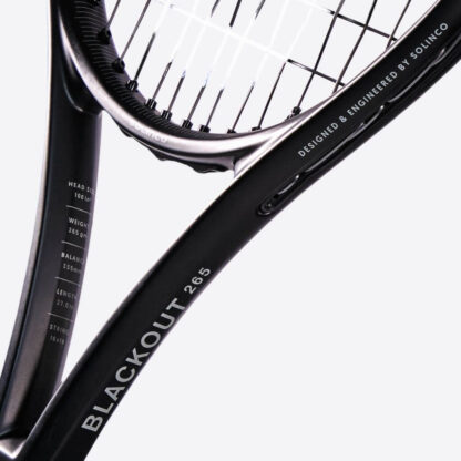 Closeup of throat of black matte and glossy tennis racquet from Solinco. Black grip. BlackOut in white writing on the side with white Solinco logo. Solinco BlackOut 265 model.